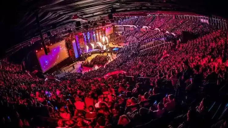 A crowd seated at the arena next to a light up stage for the IEM katowice tournament