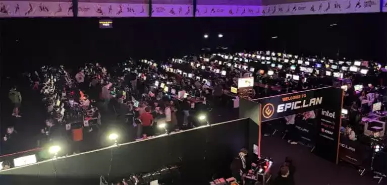 Rows of desks with computers set up and people sat at them competing in the Epic 40 Lan