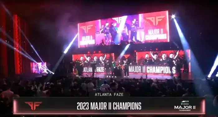 Image displaying crowds surrounding a stand with Major 2 champions FaZe celebrating on stage. Lights and monitors showing pictures of the winners