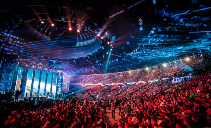 A crowd seated at the arena next to a light up stage for the IEM katowice tournament